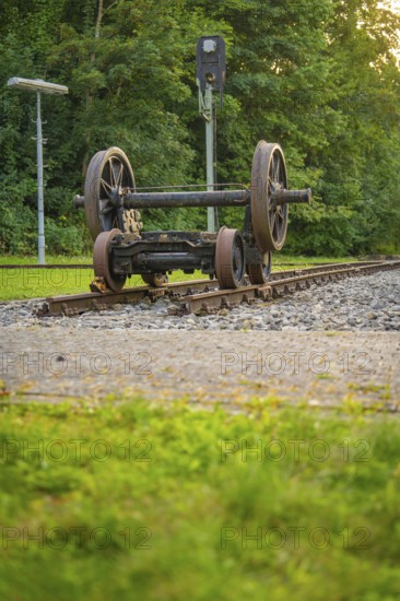 Two upturned train wheels on tracks against a green background. Atmosphere of peace and nature,