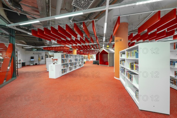 A modern library with eye-catching red and white elements creates a lively atmosphere, Munich,
