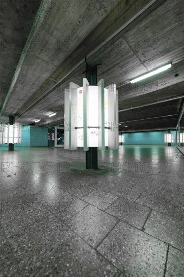 An empty, underground space with concrete walls and glowing green light creates a modern, urban