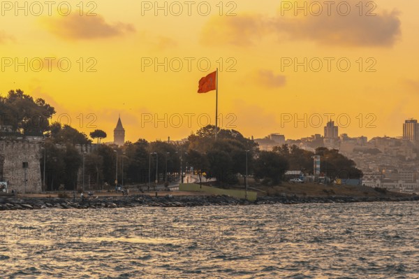 Scenic sunset view of istanbul's cityscape, featuring the prominent galata tower and a waving