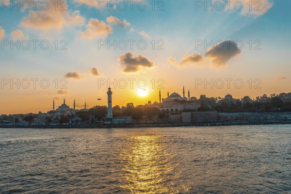 Golden sunset illuminating hagia sophia and ancient lighthouse in the bosphorus strait in istanbul,