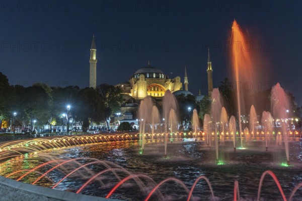Colorful illuminated fountain jets dancing in front of the hagia sophia in istanbul, turkey,