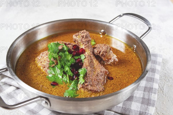 Fesenjan, an Iranian dish, stewed chicken, in a nut-pomegranate sauce, in a saucepan, light
