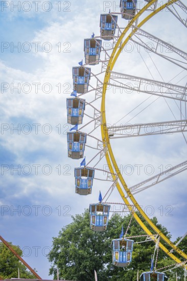 Detailed view of a giant Ferris wheel with blue cabins in front of a blue sky, Olympic Park,