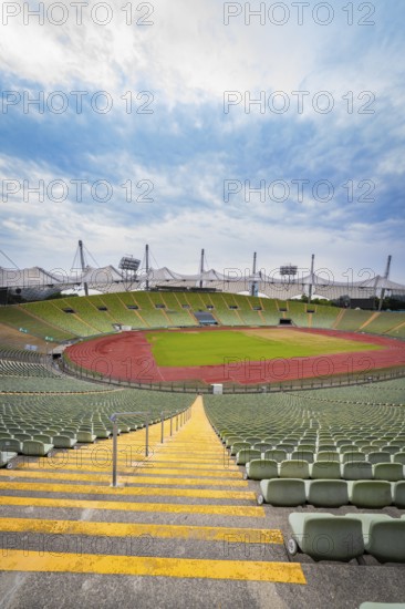 Symmetrical view of a stadium from a staircase with red running track and green stands, Olympic