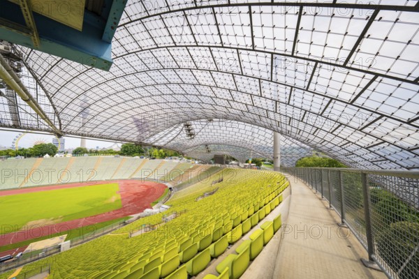 Walk along empty stands in the stadium with a view of a wide playing field, Olympiapark, Munich,
