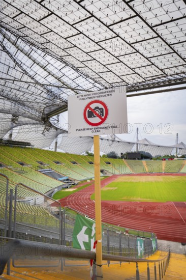 View of stadium grandstand and running track, dominated by a metal grid construction and