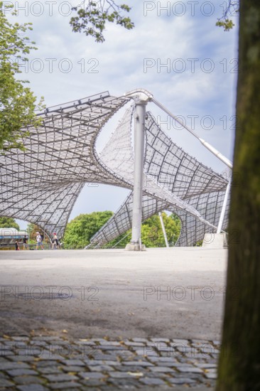 Modern architectural structure with lattice roof and a tree in the foreground, Olympiapark, Munich,