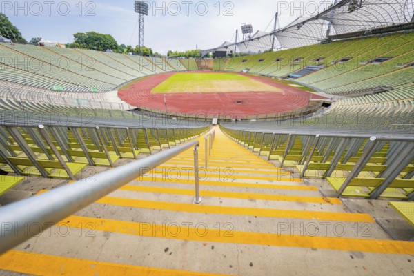 Central view of the stadium from the stairs onto empty stands and red running track, Olympic Park,