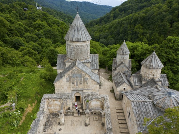 Aerial view of a classical monastery in the middle of dense forests and hilly landscape, aerial