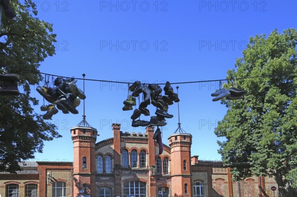 Shoes hanging on a leash, in the courtyard of a residential home for addicts, each shoe is a