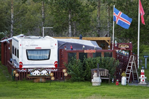 Icelandic permanent camper with full decoration and Icelandic flag at the campsite in Uthlid in