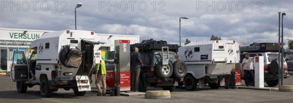 Several off-road vehicle drivers refuelling at self-service petrol stations, Reykjalith, Myvatn,