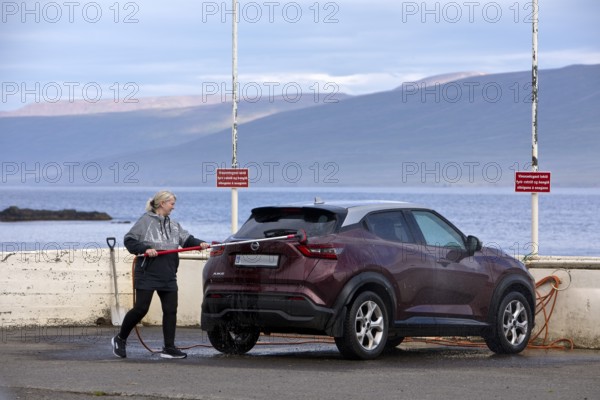 Washing the car with the free water brush at the petrol station by the Vopnafjördur fjord, East