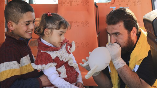 Displaced Syrian children receiving urgent medical intervention inside an ambulance, reflecting the