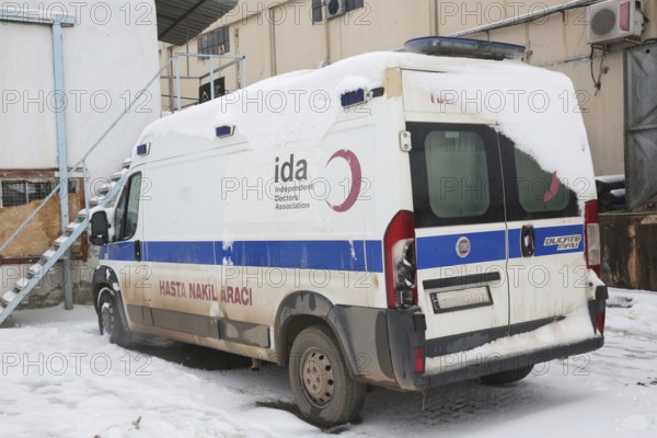 An ambulance parked at the entrance of an informal refugee camp, prepared for any medical