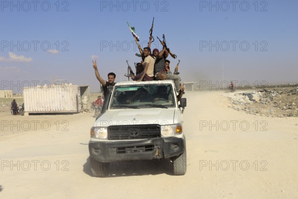 Fighters from the Free Syrian Army celebrate victory after capturing villages that were under the