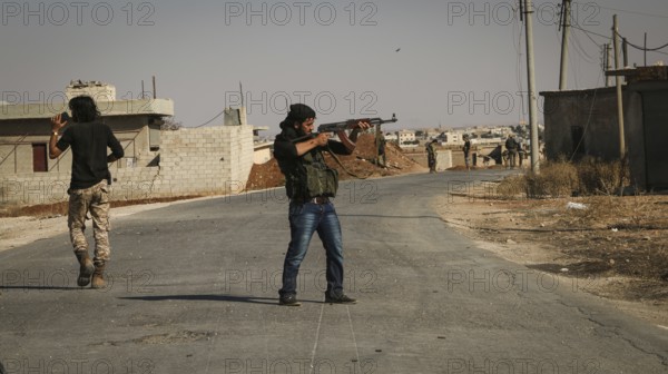 Syrian opposition fighters firing small arms and heavy weapons during the expulsion of ISIS