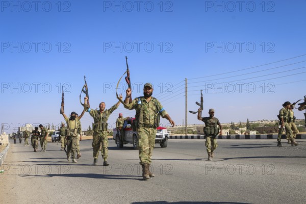 Fighters from the Free Syrian Army celebrate victory after capturing villages that were under the