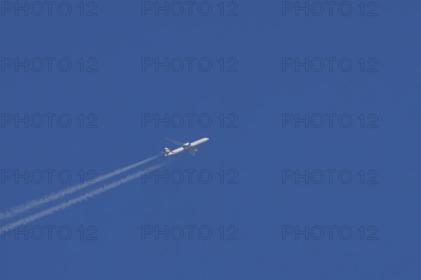 Airbus jet passenger aircraft of Emirates airlines flying with vapour trails or contrails behind in