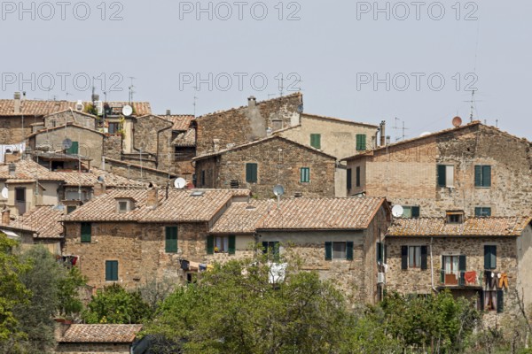 Houses with tiled roofs and antennas, surrounded by green vegetation, in a Mediterranean, rustic