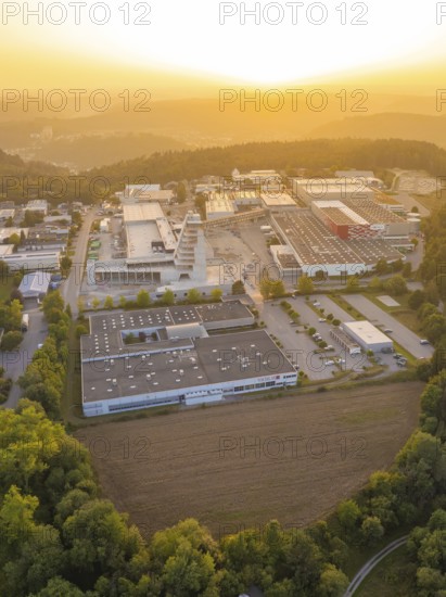 Industrial area surrounded by forests and hills in the evening light of the sunset, industrial area