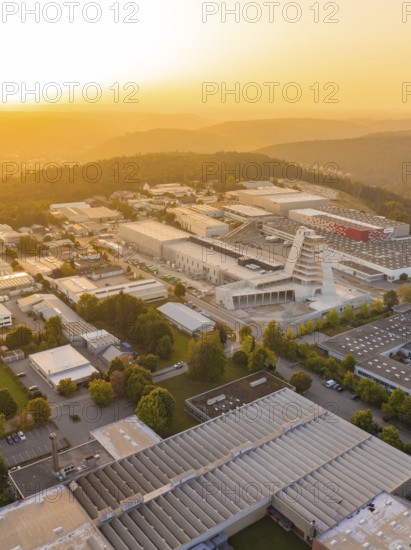 Industrial complex at sunset surrounded by hills and forests, industrial area Wolfsberg Nagold,