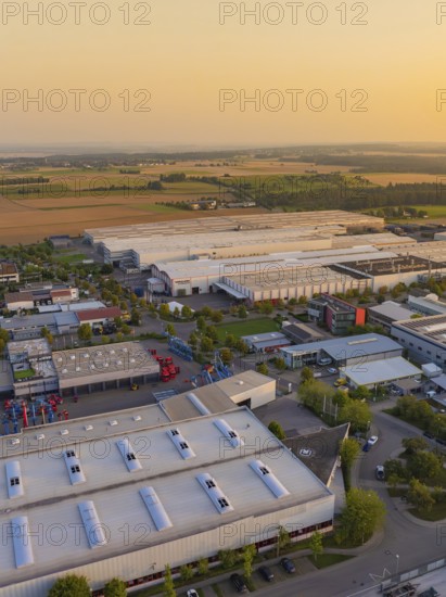 Industrial buildings and roads near fields with vehicles and urban development, Wolfsberg Nagold