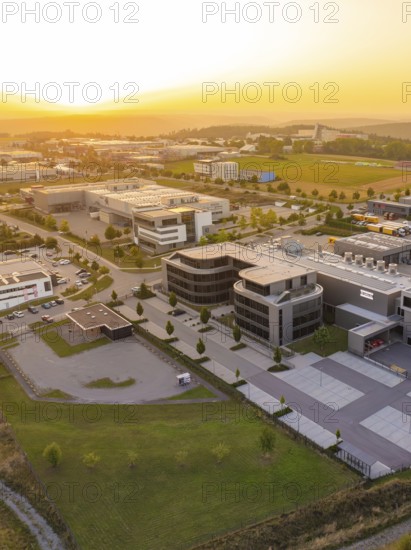 Modern commercial building with car park in a rural setting at sunset, industrial area Wolfsberg
