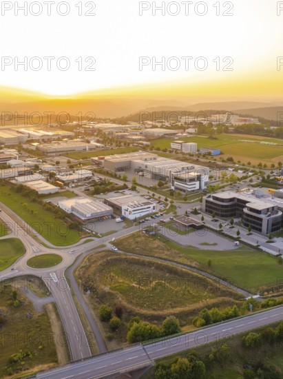Industrial area in the sunset, surrounded by fields and forests with modern buildings, industrial
