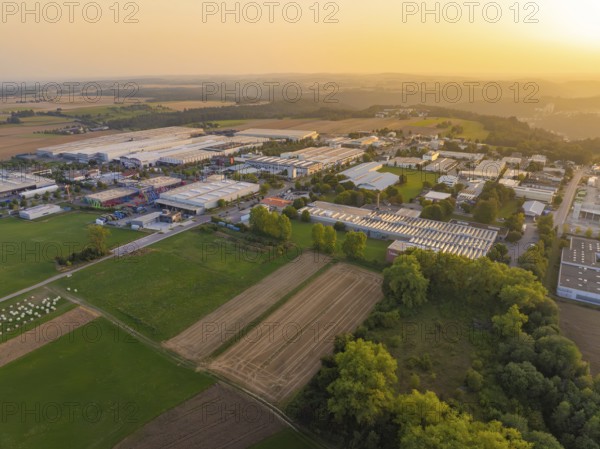 Industrial warehouses and fields in a vast rural landscape at sunset, Wolfsberg Nagold industrial