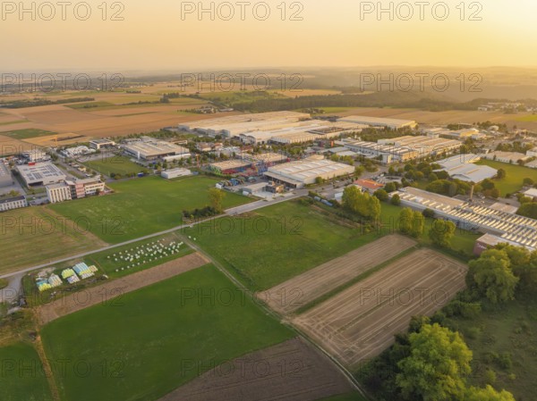 View of an industrial area surrounded by agricultural land in the evening light, Wolfsberg Nagold