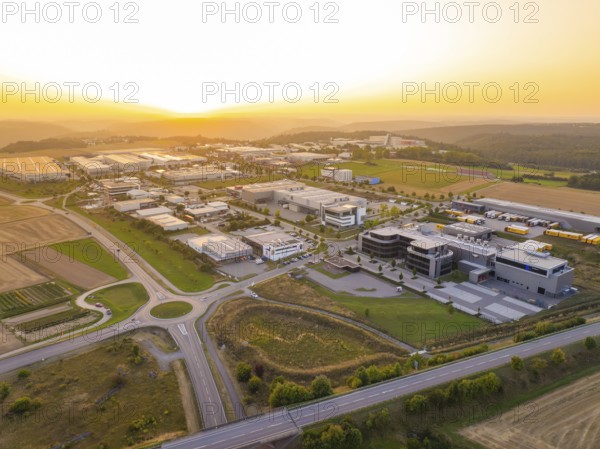 Wide view of an industrial area at sunset, surrounded by fields and forests, industrial area