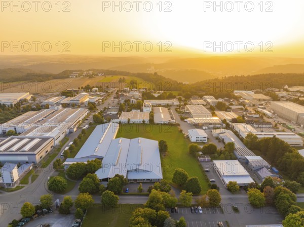 Industrial complex with surrounding green areas and fields at sunset, industrial area Wolfsberg
