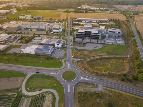 Industrial area with central roundabout, adjacent to fields and modern buildings, industrial area
