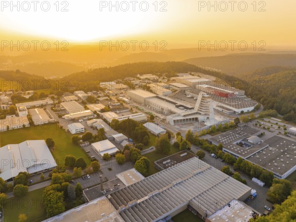 Extensive industrial complex embedded in wooded hills at sunset, industrial area Wolfsberg Nagold,