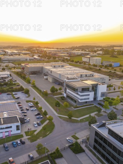 Industrial area at sunset with modern buildings, orderly streets and car parks, industrial area