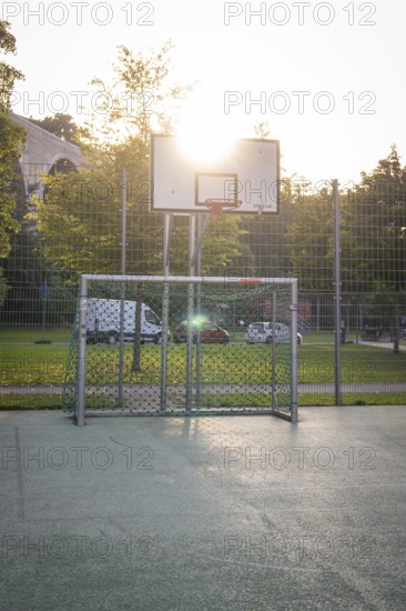 An outdoor basketball court with a basket and sunlight in the background, Nagold, district of Calw,
