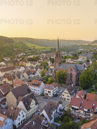 Village-like urban landscape with church and surrounding hills in the evening light, Nagold,