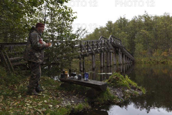 Tourist at the bridge over the Drosedower Bek, Müritz National Park, Mecklenburg-Western Pomerania,