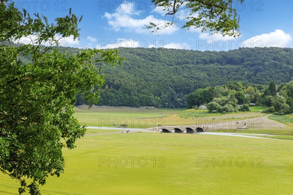 View of historic old bridge over river Eder has fallen completely dry during drought in old Eder