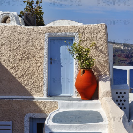 Red vase in front of a yellow wall, light blue door, holiday home, Oia, Thira, Santorini, Cyclades,