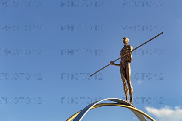 Sculpture Balance by the artist Martina Ondáková in front of a blue sky, human figure balanced,