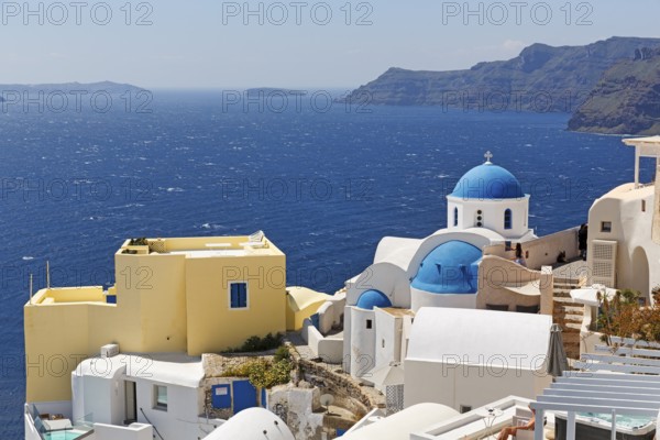 Yellow holiday home by the sea, with typical roof terrace, orthodox church with blue dome, view