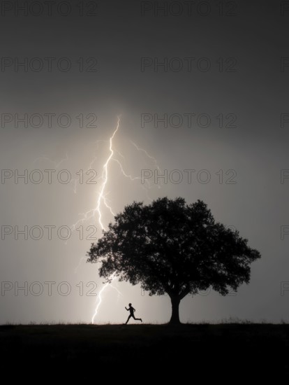 A person runs past a tree in the dark while lightning strikes in the background, danger to life due