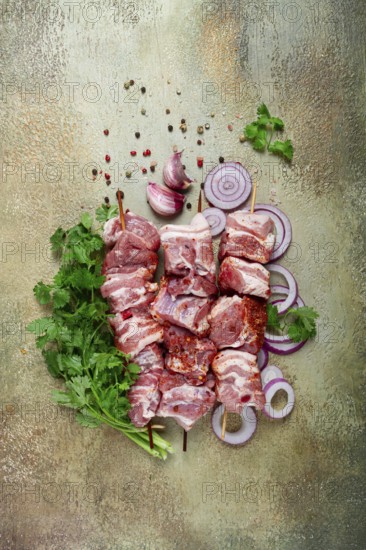 Raw pork meat, on wooden skewers, pickled kebab, with spices and herbs, on the table, top view, no