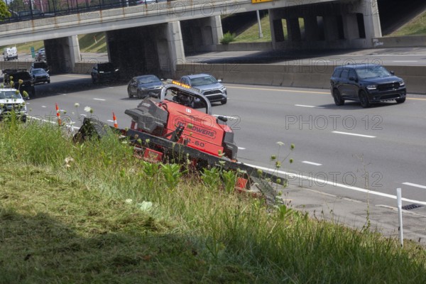 Harper Woods, Michigan - Remote-control mowers are cutting the grass and weeds along Interstate 94