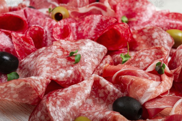 Assorted, meat appetizer, prosciutto, salami and ham, with olives, close-up, breakfast, top view,