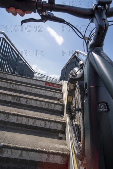 Staircase with bicycle channel, for pushing the bicycle, on the bicycle and pedestrian bridge