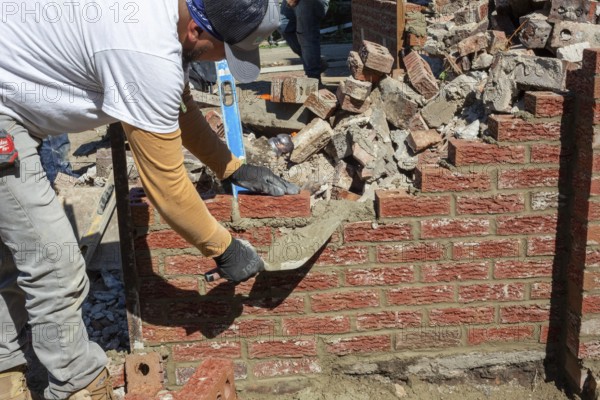 Detroit, Michigan - Workers rebuild the front porch of a house they are remodeling in the